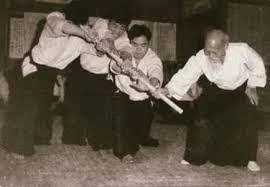 O-Sensei practicando con armas ante varios atacantes